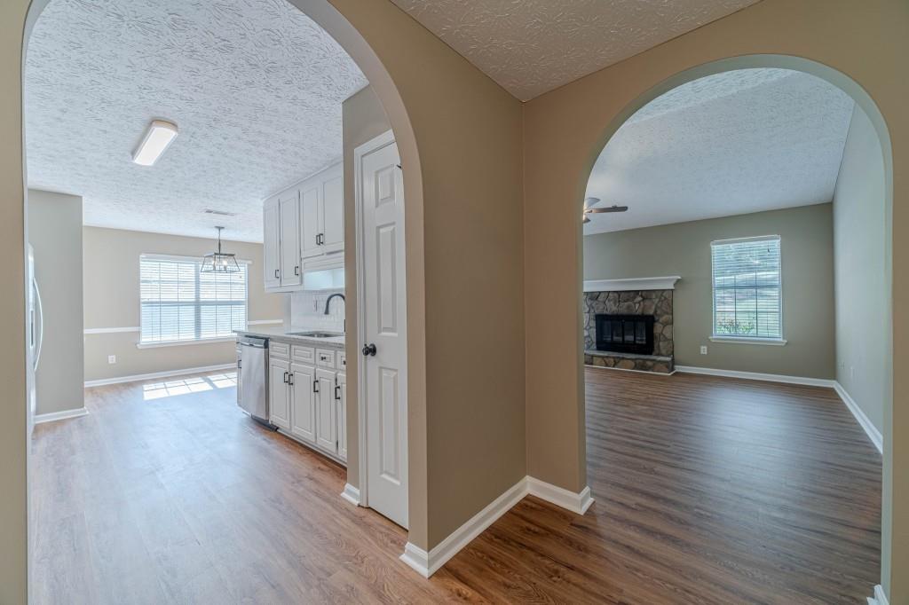 701 Woodland Ridge Drive Monroe, GA 30656 - Photo 12 of 39 an empty room with wooden floor fireplace and windows