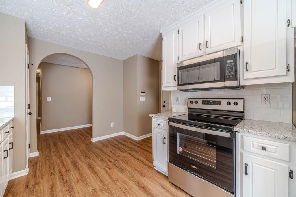 701 Woodland Ridge Drive Monroe, GA 30656 - Photo 13 of 39 a kitchen with cabinets wooden floor and stainless steel appliances