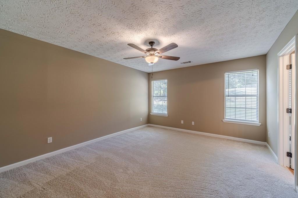 701 Woodland Ridge Drive Monroe, GA 30656 - Photo 19 of 39 an empty room with windows and ceiling fan