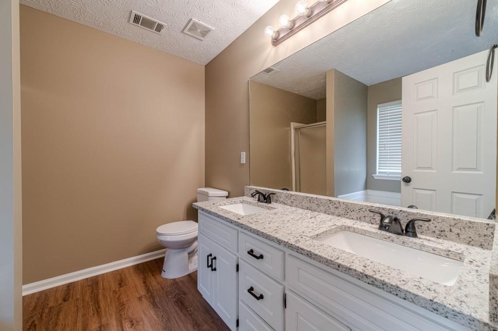 701 Woodland Ridge Drive Monroe, GA 30656 - Photo 23 of 39 a bathroom with a granite countertop sink a toilet and a mirror