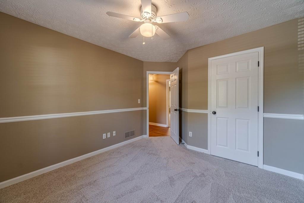 701 Woodland Ridge Drive Monroe, GA 30656 - Photo 30 of 39 an empty room with closet and a ceiling fan