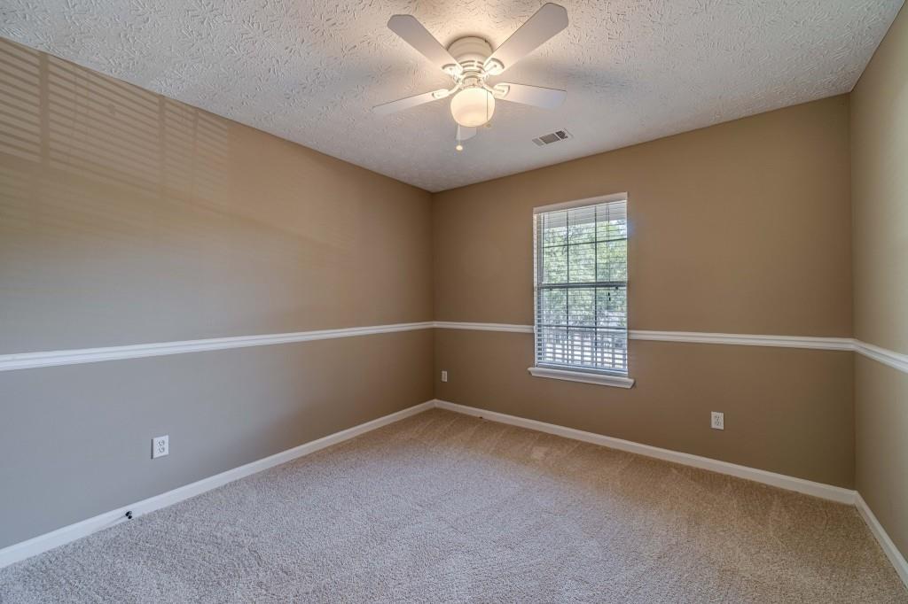 701 Woodland Ridge Drive Monroe, GA 30656 - Photo 31 of 39 an empty room with a window and a fan