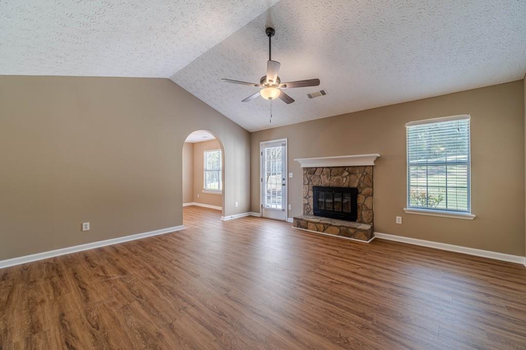701 Woodland Ridge Drive Monroe, GA 30656 - Photo 7 of 39 an empty room with wooden floor fireplace fan and windows