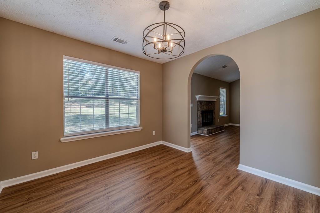 701 Woodland Ridge Drive Monroe, GA 30656 - Photo 9 of 39 an empty room with wooden floor fan and windows
