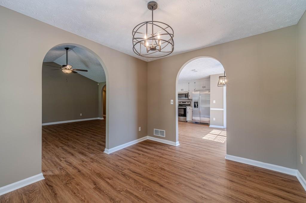 701 Woodland Ridge Drive Monroe, GA 30656 - Photo 10 of 39 an empty room with wooden floor mirror and windows