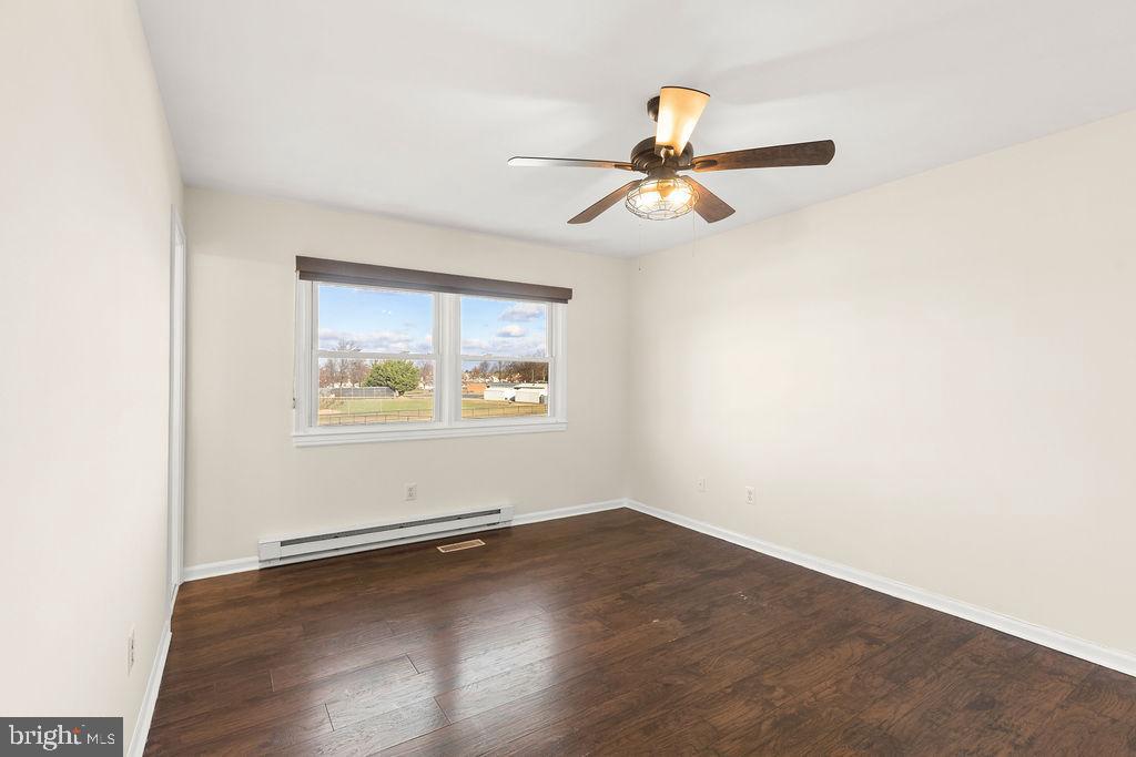 503 South Maple Court Sterling, VA 20164 - Photo 24 of 43 an empty room with wooden floor ceiling fan and windows