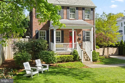 a view of a brick house with a yard and plants