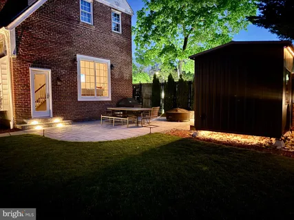 a backyard of a house with table and chairs with wooden fence