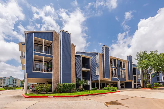 a front view of a building with street view and trees