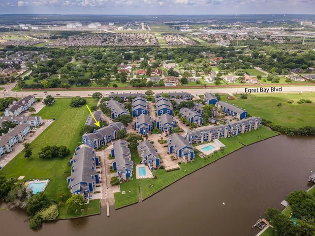 an aerial view of a city with lots of residential buildings ocean and mountain view in back