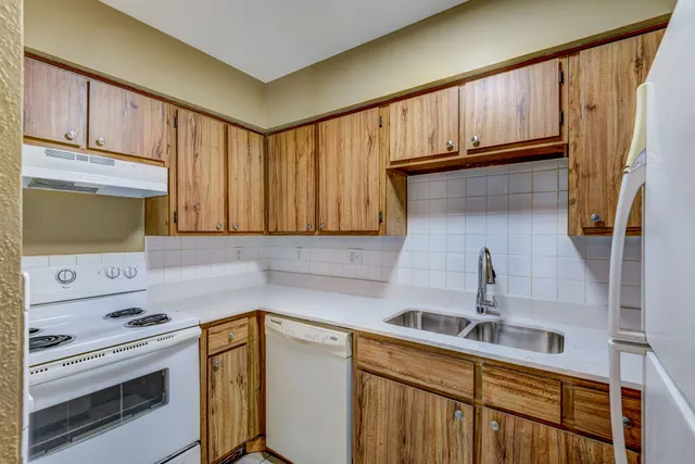 a kitchen with a sink cabinets and a stove top oven