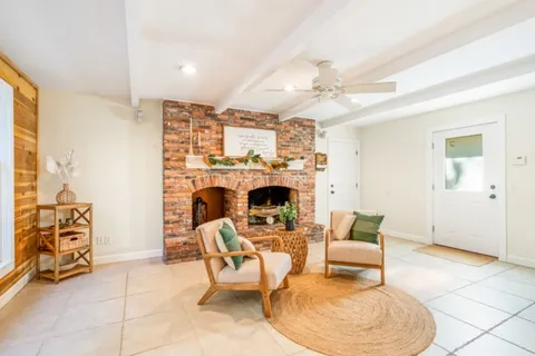 a living room with furniture a fireplace and a chandelier