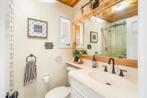 a bathroom with a sink a toilet and a large mirror