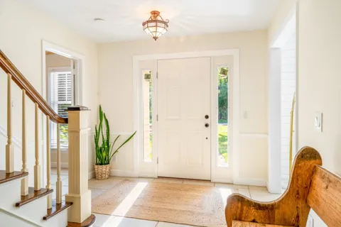 a view of a livingroom with furniture a ceiling fan and windows