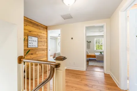 a view of a hallway with wooden floor and furniture