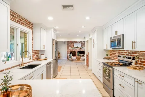 a kitchen with stainless steel appliances kitchen island granite countertop a sink and cabinets