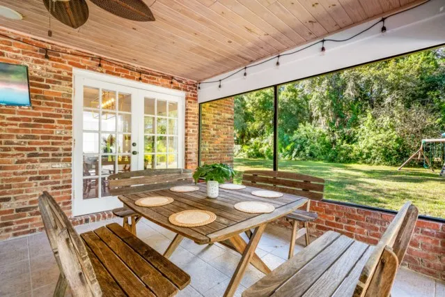 a view of a patio with table and chairs with wooden floor and fence