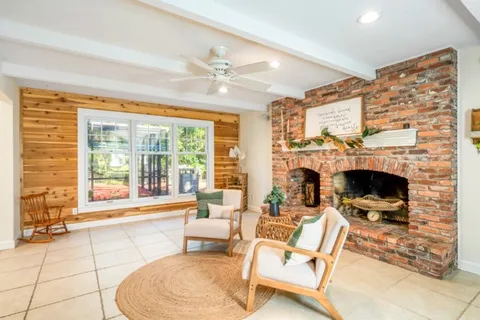 a living room with furniture a large window and a fireplace