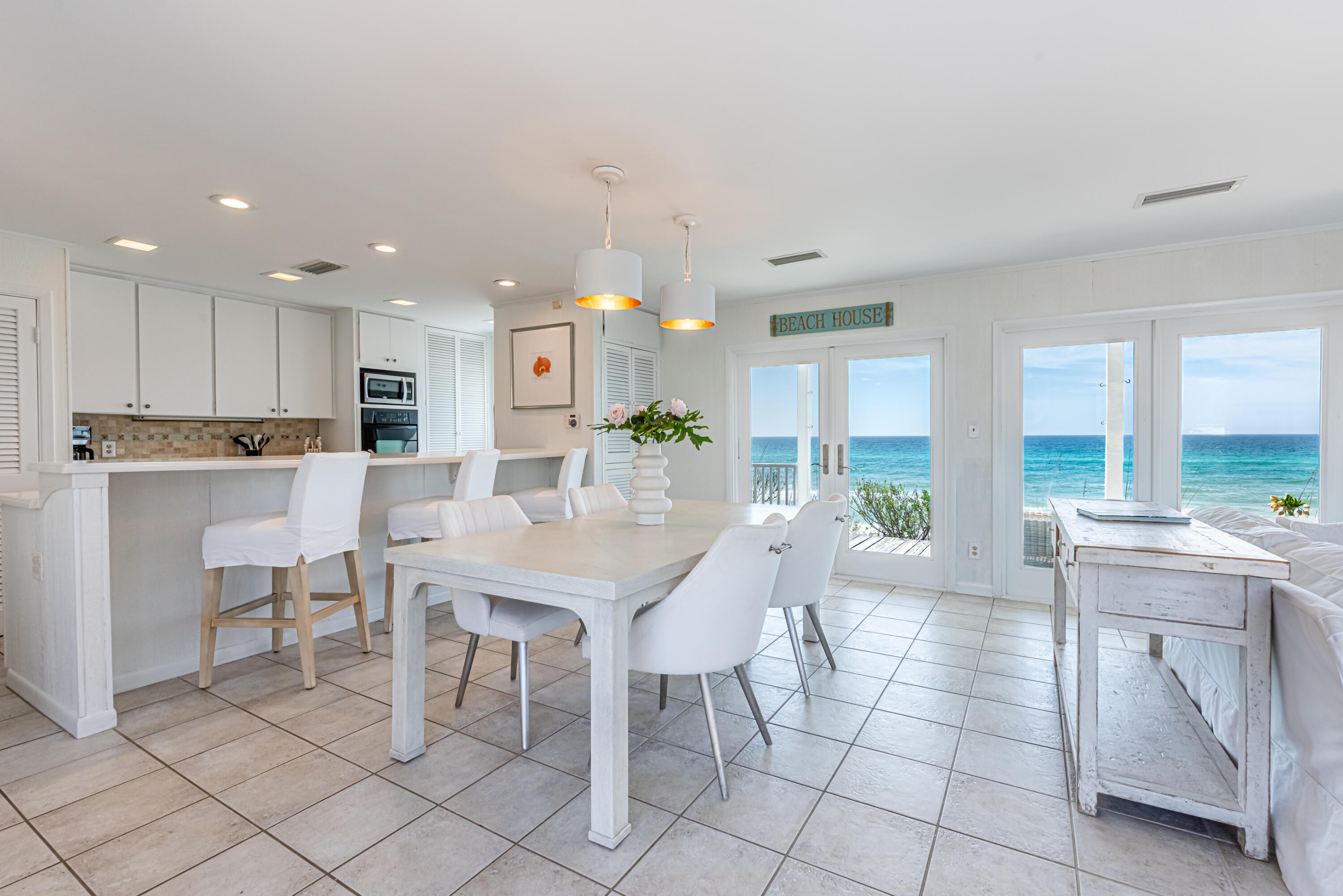 4731 West County Highway 30A Santa Rosa Beach, FL 32459 - Photo 13 of 44 a large white kitchen with a table and chairs