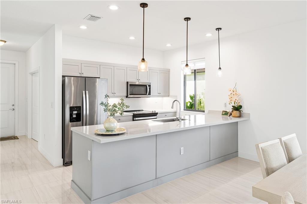 4951 Brigata Way Avenue Immokalee, FL 34142 - Photo 2 of 49 a kitchen with kitchen island a counter top space appliances and cabinets