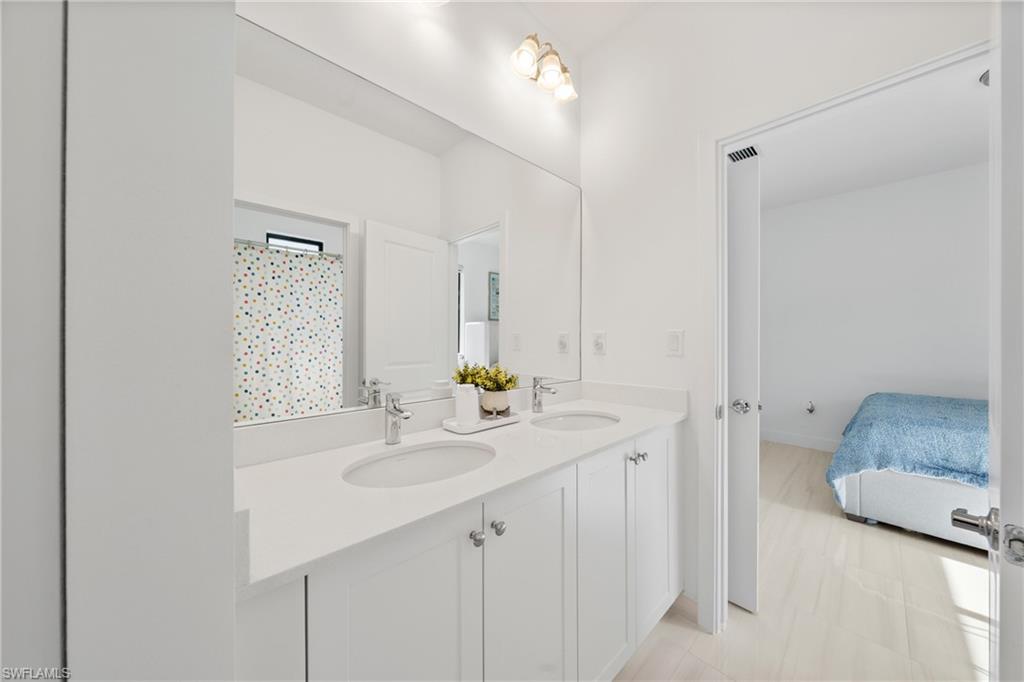 4951 Brigata Way Avenue Immokalee, FL 34142 - Photo 21 of 49 a bathroom with a sink double vanity and a mirror