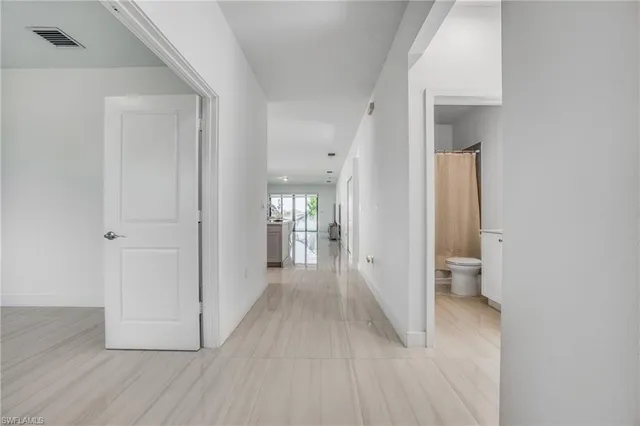 a view of a hallway with wooden floor and closet