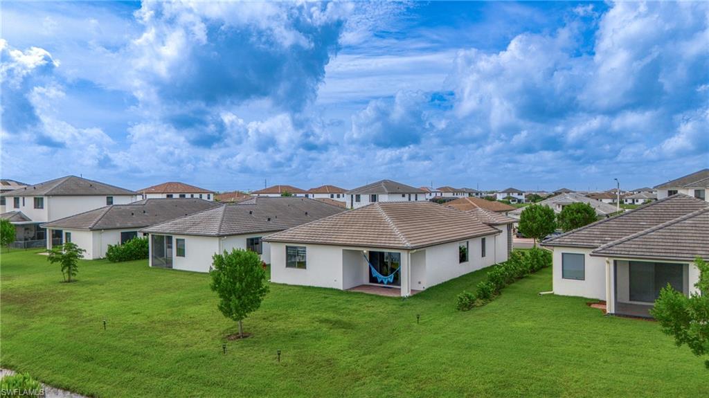 4951 Brigata Way Avenue Immokalee, FL 34142 - Photo 32 of 49 a view of a white house with a big yard and potted plants