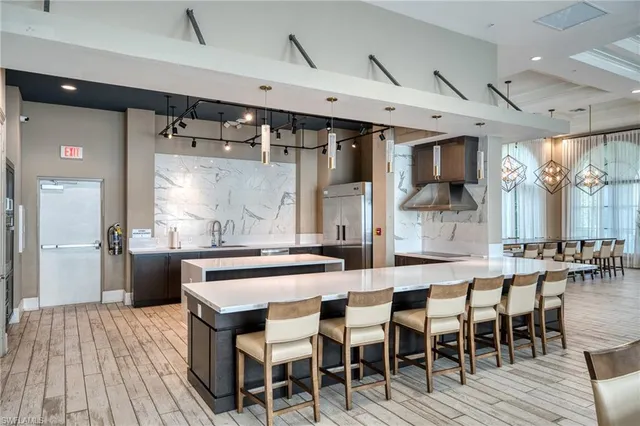 an open kitchen with chandelier dining table and wooden floor