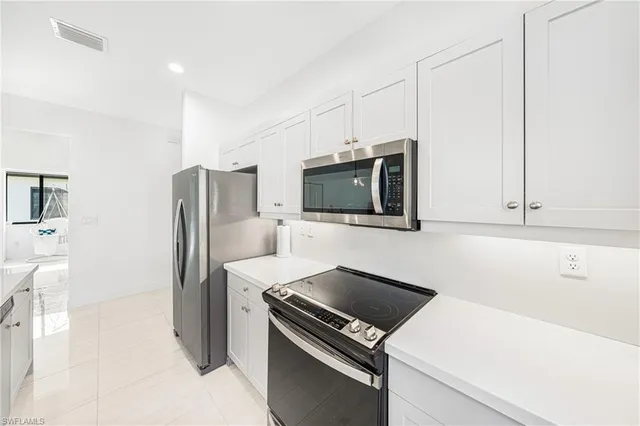 a kitchen with stainless steel appliances a refrigerator stove and microwave