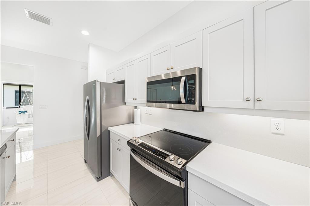 4951 Brigata Way Avenue Immokalee, FL 34142 - Photo 8 of 49 a kitchen with stainless steel appliances a refrigerator stove and microwave