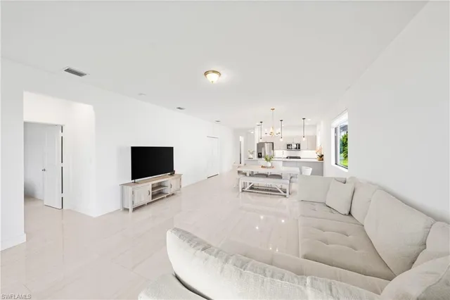 a kitchen with kitchen island white cabinets and a potted plant