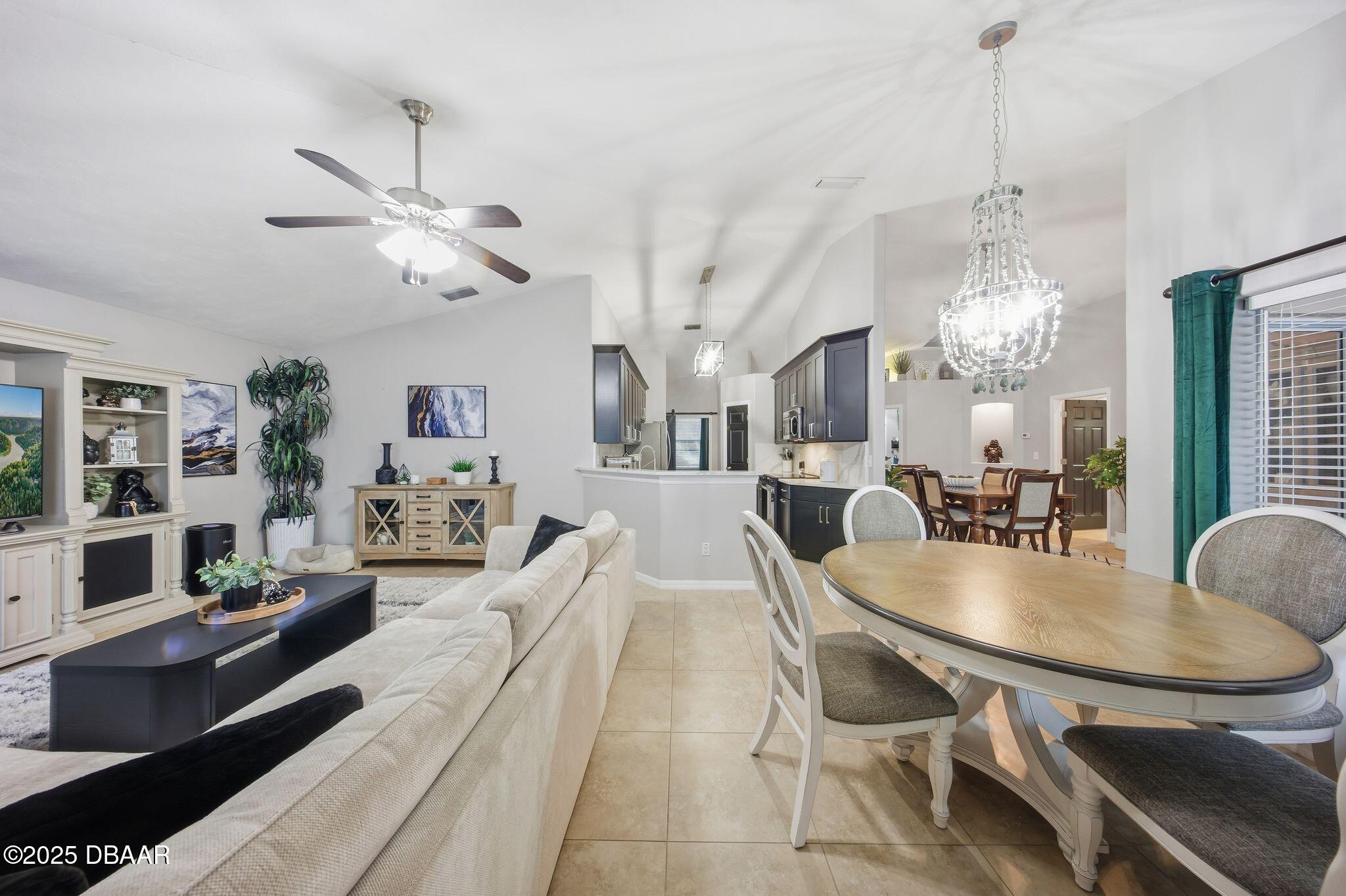 6127 Sabal Point Circle Port Orange, FL 32128 - Photo 9 of 53 a living room with dining table and a chandelier