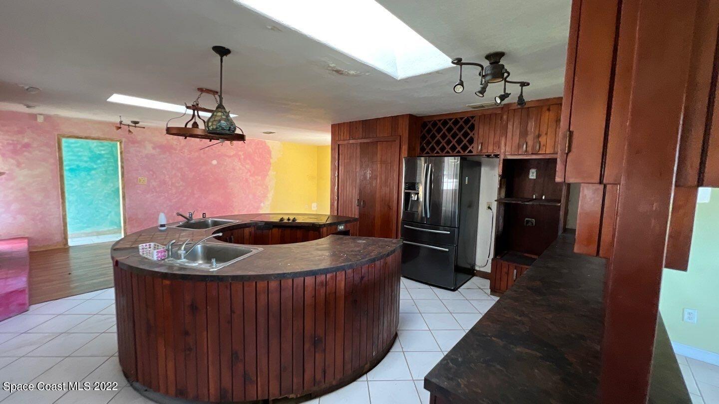 1455 Martin Road Rockledge, FL 32955 - Photo 9 of 18 a kitchen with stainless steel appliances granite countertop a sink dishwasher and a refrigerator