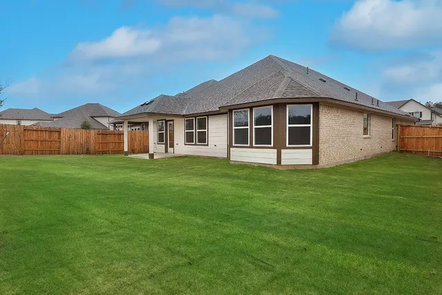 a view of a white house with a yard and large trees