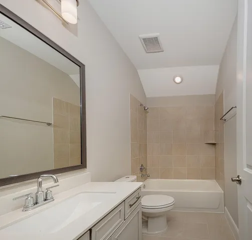 a bathroom with a granite countertop sink a toilet a mirror and shower