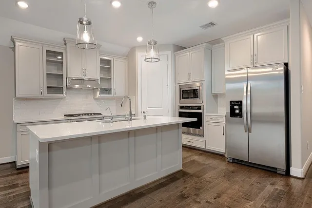 a kitchen with stainless steel appliances a refrigerator sink and microwave