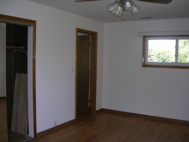 607 Elmhurst Road Mount Prospect, IL 60056 - Photo 14 of 24 an empty room with wooden floor closet and windows