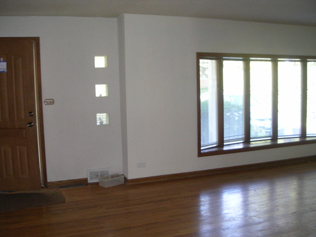 607 Elmhurst Road Mount Prospect, IL 60056 - Photo 17 of 24 an empty room with wooden floor and windows
