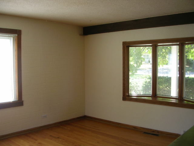 607 Elmhurst Road Mount Prospect, IL 60056 - Photo 6 of 24 a view of an empty room with wooden floor and a window