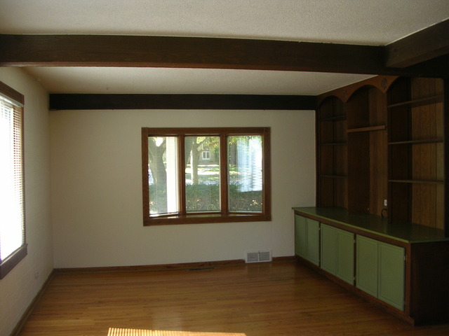 607 Elmhurst Road Mount Prospect, IL 60056 - Photo 8 of 24 a view of an empty room with wooden floor and a window