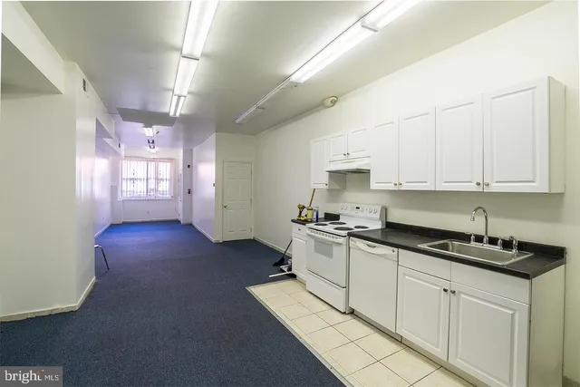 a kitchen with granite countertop a stove a sink dishwasher and a refrigerator with wooden floor