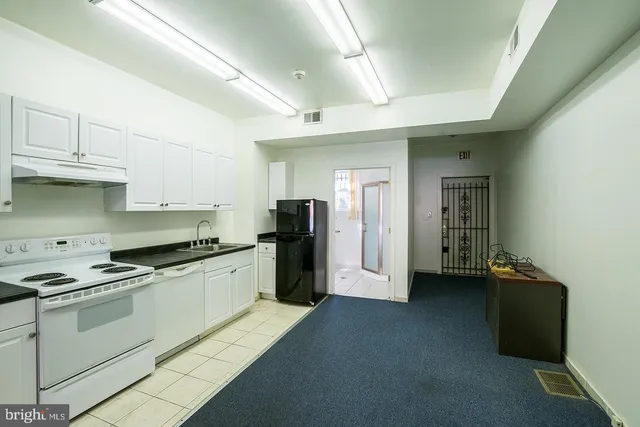 a kitchen with granite countertop a refrigerator stove and sink