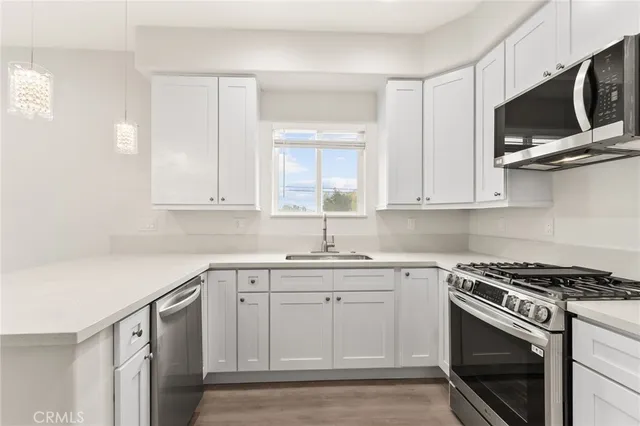 a kitchen with white cabinets stainless steel appliances and sink