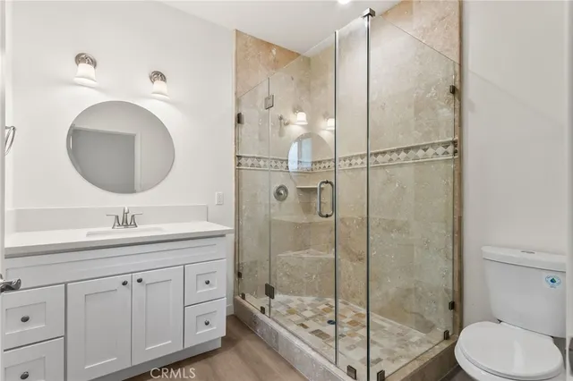a bathroom with a granite countertop sink toilet and shower