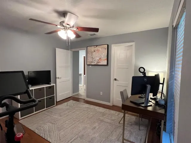 a view of a workspace with furniture and a window
