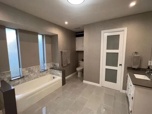 a bathroom with a tub sink and mirror