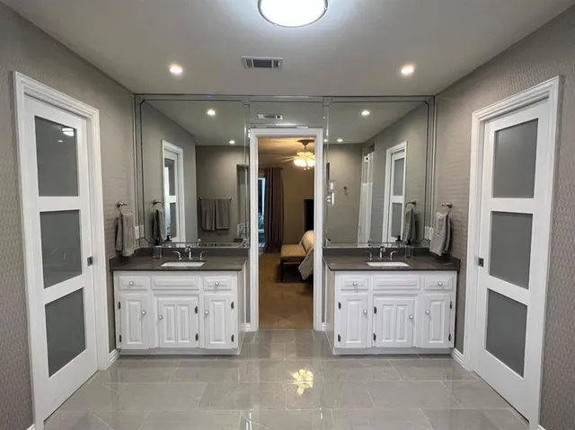 a large bathroom with double vanity and mirrors