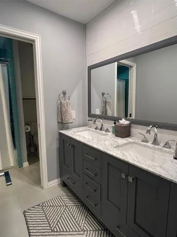 a bathroom with double vanity and a mirror