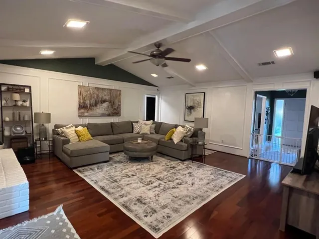 a living room with furniture and wooden floor