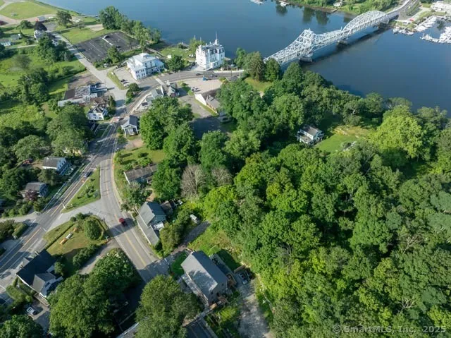 an aerial view of residential house with outdoor space and trees all around